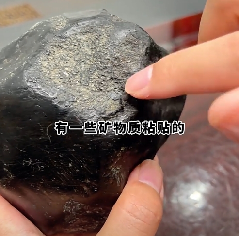 图9 黑色腊皮壳上带矿渣